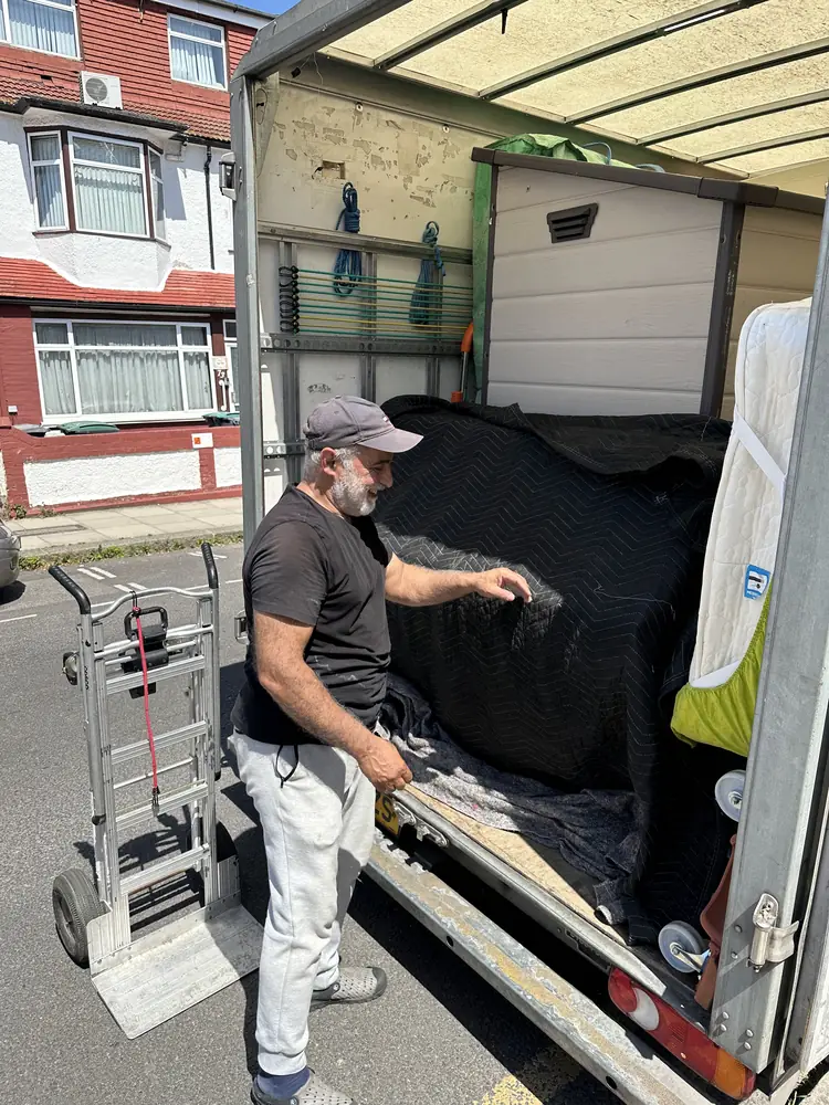 Ali loading wrapped furniture on a residential street