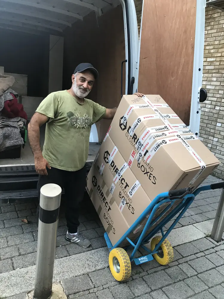 Ali moving stacked boxes on a sack truck