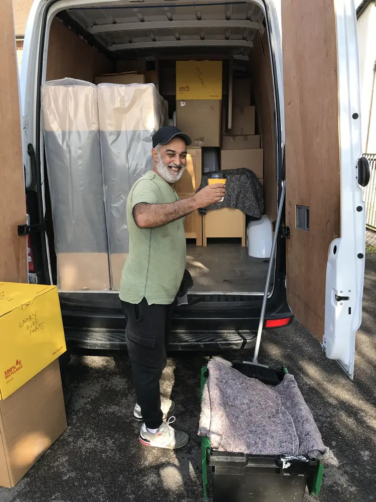 Ali at the van with a wrapped mattress and boxes