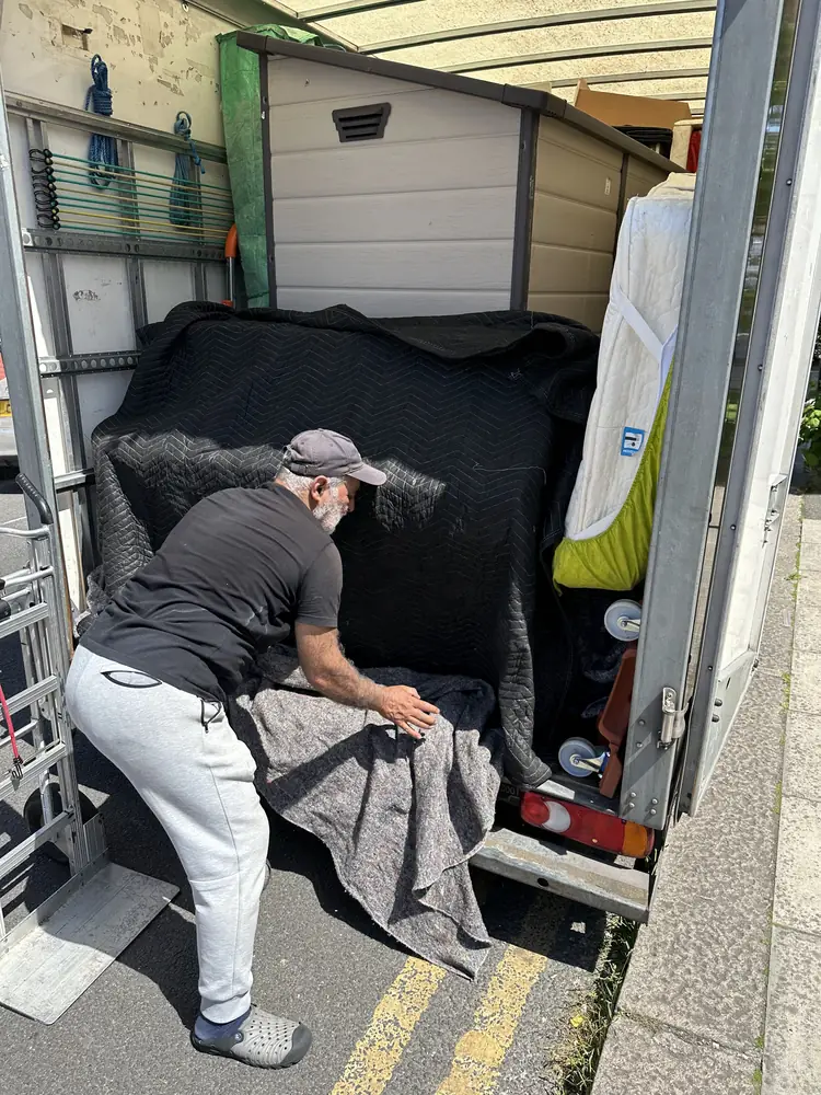 Ali wrapping furniture beside the van