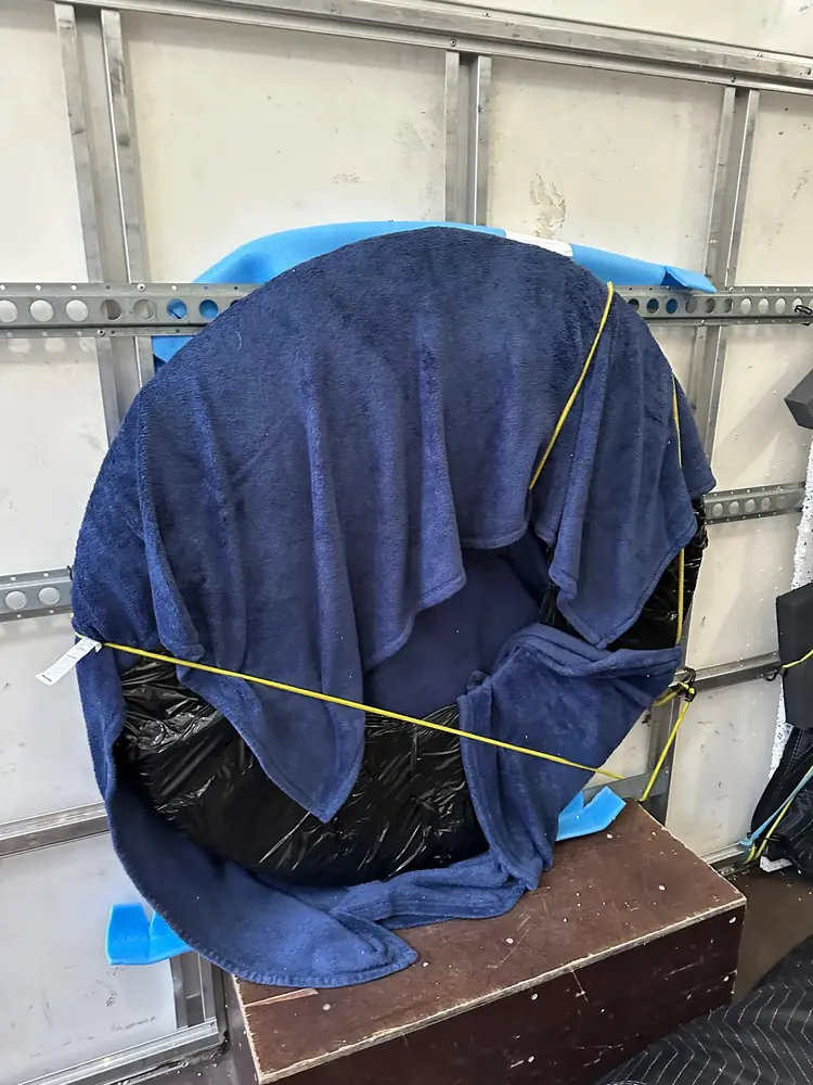Blanket-wrapped furniture strapped to the van wall