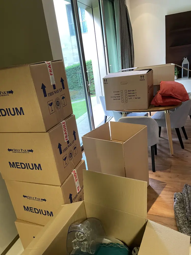 Labelled boxes stacked by the window before a move