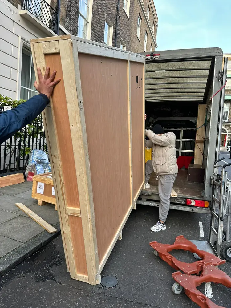 Unloading a large crated item on a London street