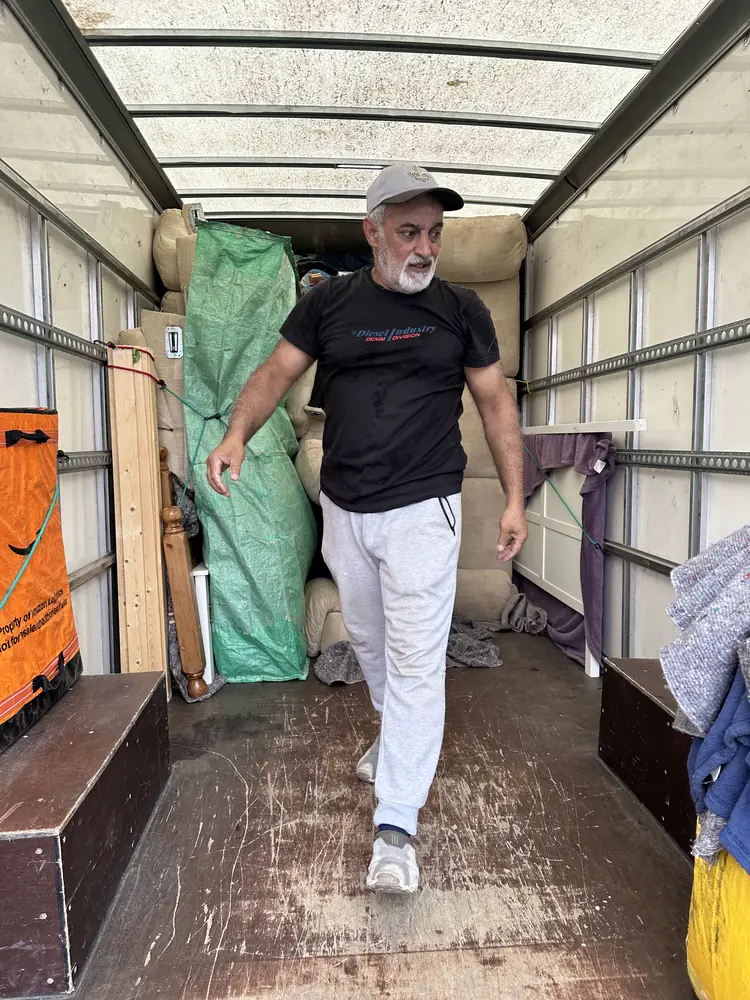 Ali inside the Luton van with wrapped furniture strapped in