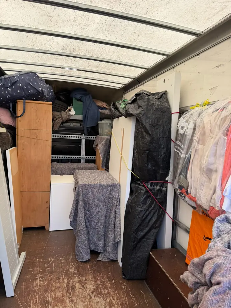 Wardrobe, boxes and hanging clothes loaded and strapped