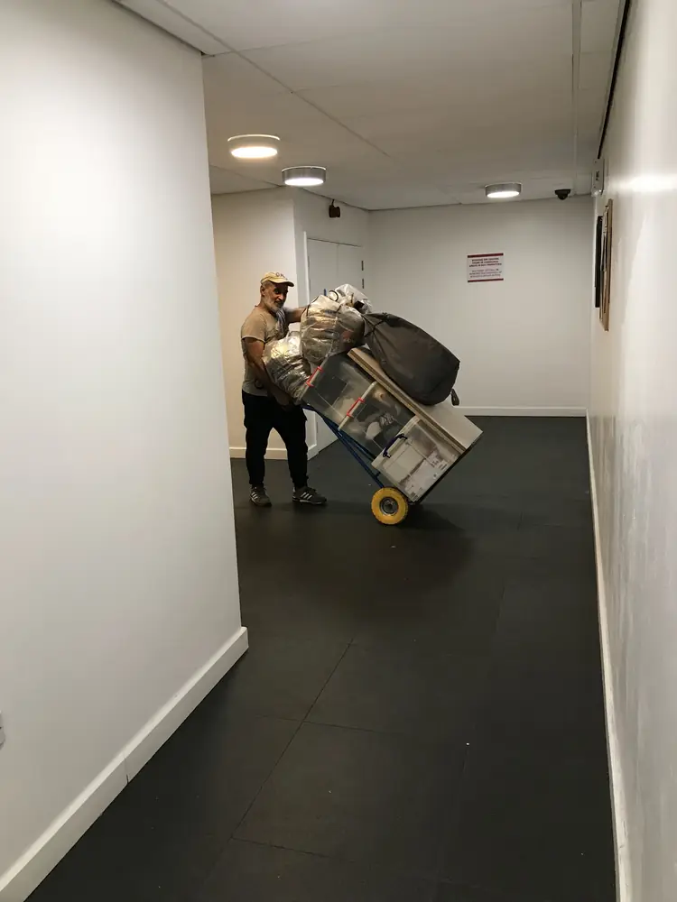 Wrapped item on a sack truck through an apartment hallway