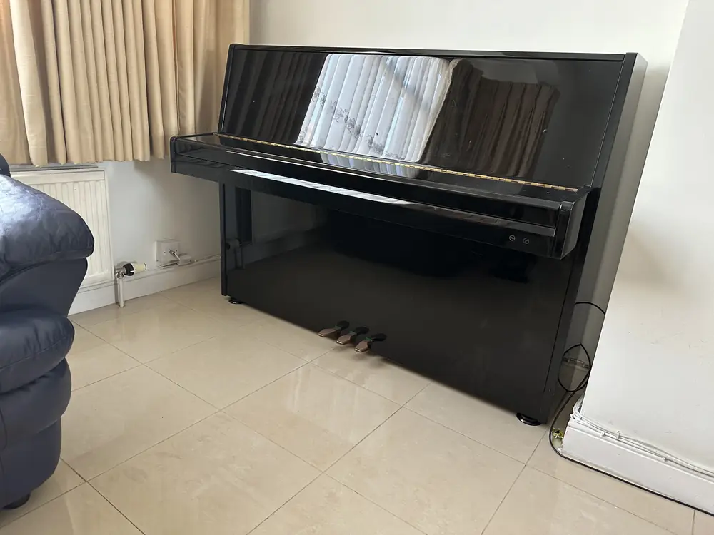 Upright piano in the customer's living room before the move