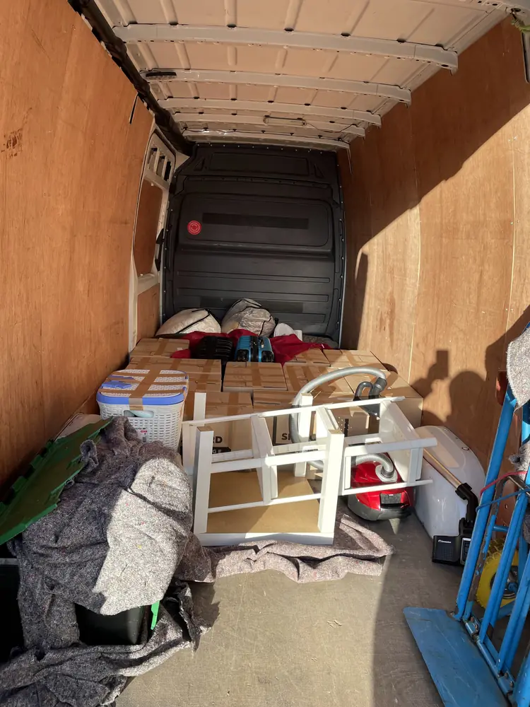 Van packed with furniture and a sack truck